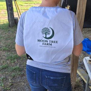 Person wearing a white Moon Tree Farm drawstring bag at the farm